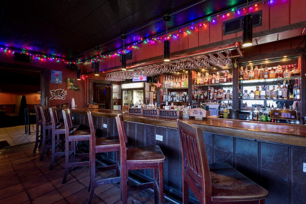The bar at Duvic's, lined with bottles and string lights